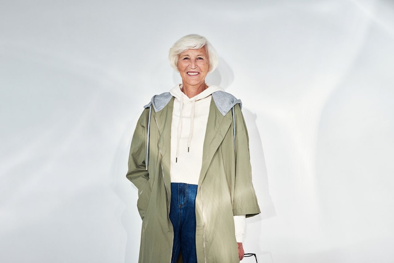 Senior woman smiling in trendy outfit with white hair and casual style.